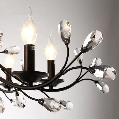 Black wrought iron decorbites crystal chandelier with faceted crystal teardrop accents and candle-style bulbs for indoor use