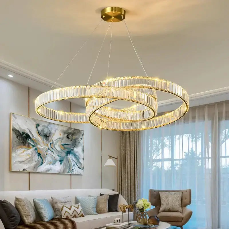 Gold-toned decorbites crystal chandelier with double rings, clear crystal accents, and integrated lighting for modern rooms