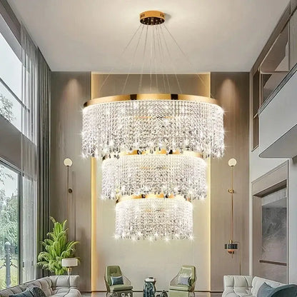 A multi-tiered decorbites crystal chandelier with gold metal accents and clear crystals for living and dining rooms