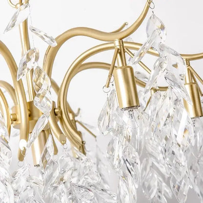 A delicate gold-toned decorbites crystal chandelier with cascading clear crystal leaves for modern luxe lighting