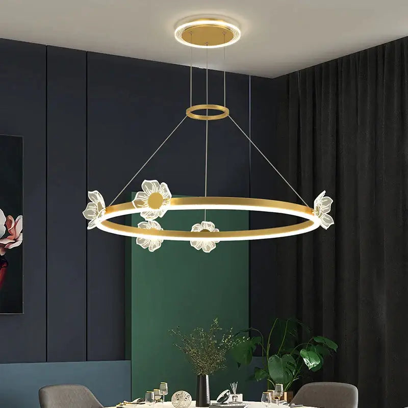 Gold-toned circular decorbites crystal chandelier with illuminated led ring and white flower accents for modern luxury lighting