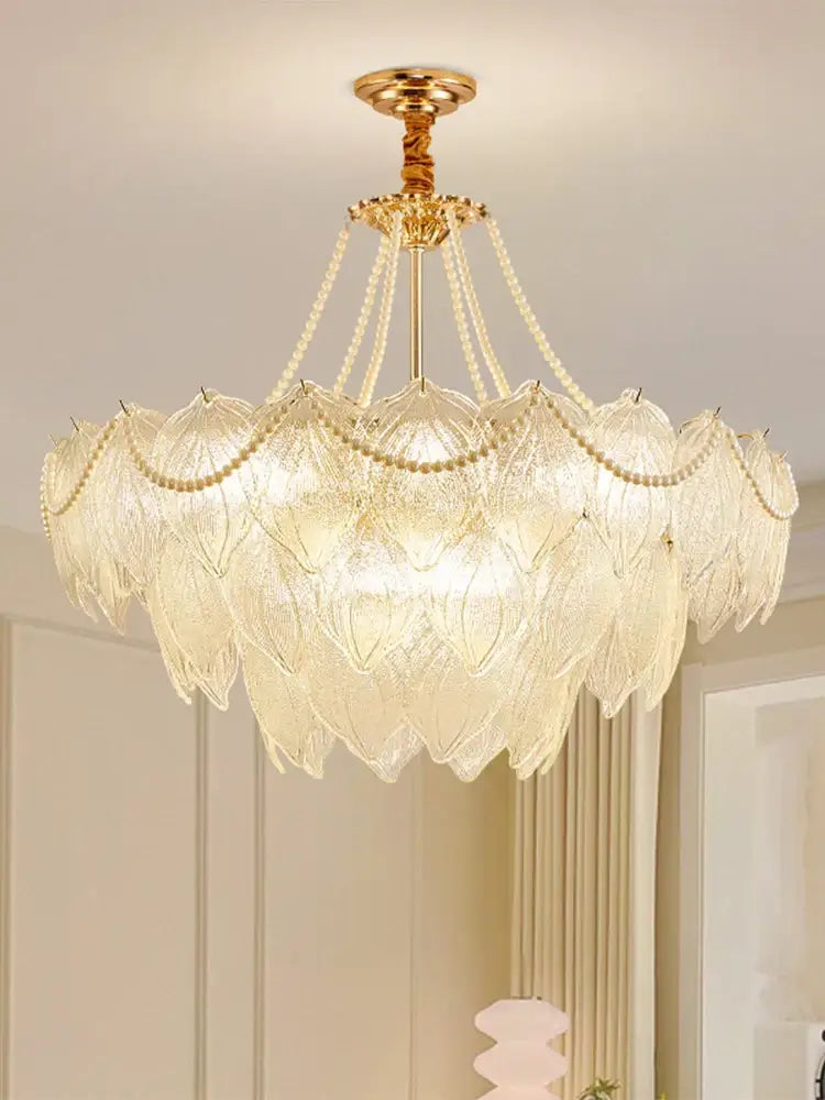 Elegant gold-toned decorbites crystal chandelier with layered glass leaf shades and beaded chains for luxury lighting