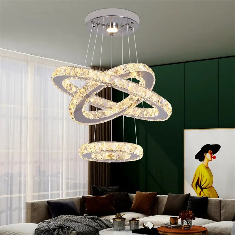 A modern decorbites crystal chandelier pendant lamp with interlocking rings and chrome finish for dining and bedroom