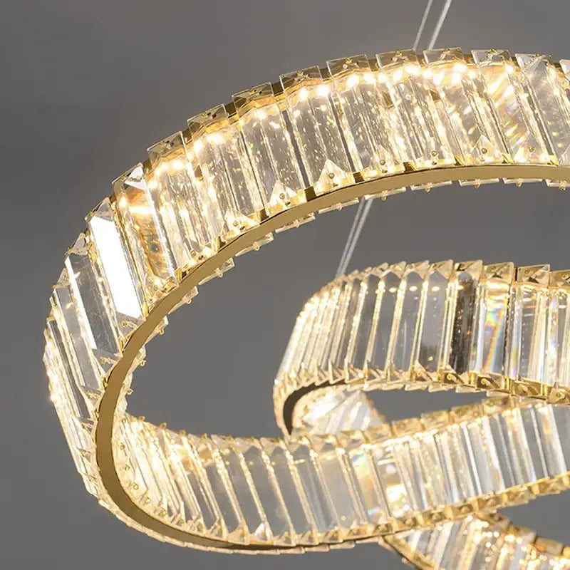 A modern decorbites crystal chandelier pendant lamp with clear rectangular crystals in a polished gold frame