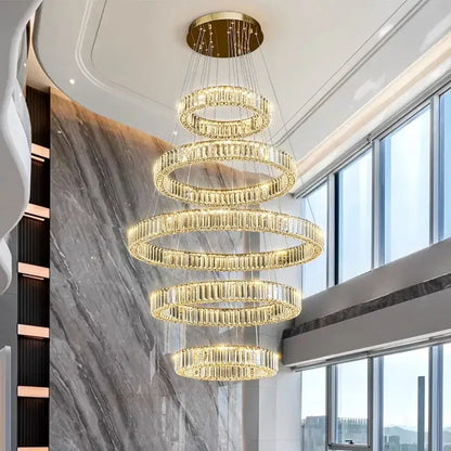 A multi-tiered decorbites crystal chandelier pendant light with cascading golden rings and clear crystal elements for indoor use