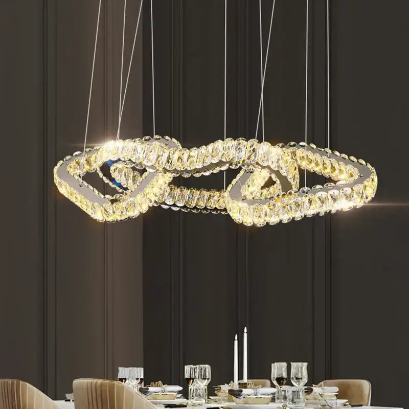 A modern decorbites crystal chandelier pendant light with double-looped crystal design and warm glowing lights for dining room
