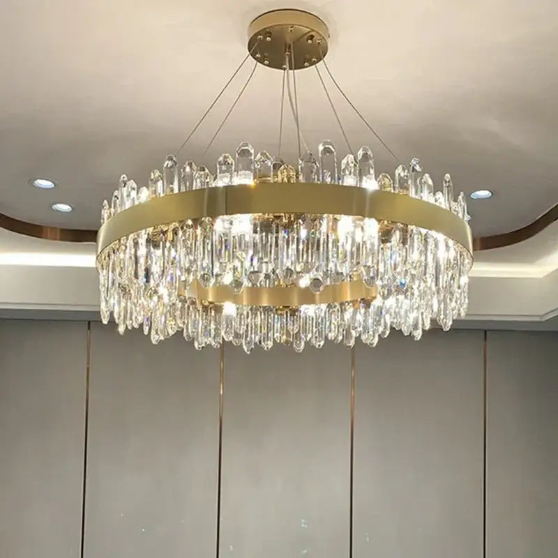 A modern decorbites crystal chandelier pendant light with gold metal frame and clear crystal prisms for luxury rooms