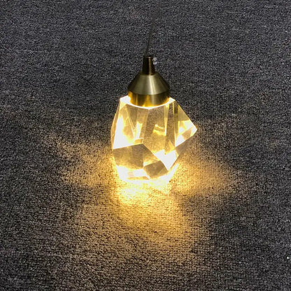A warm faceted crystal chandelier pendant with brass finish and geometric design from decorbites for dining room lighting