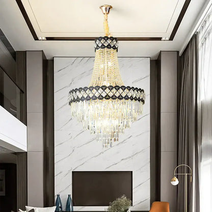 A luxurious gold-toned decorbites crystal chandelier with cascading crystals and a black diamond band for spiral staircase