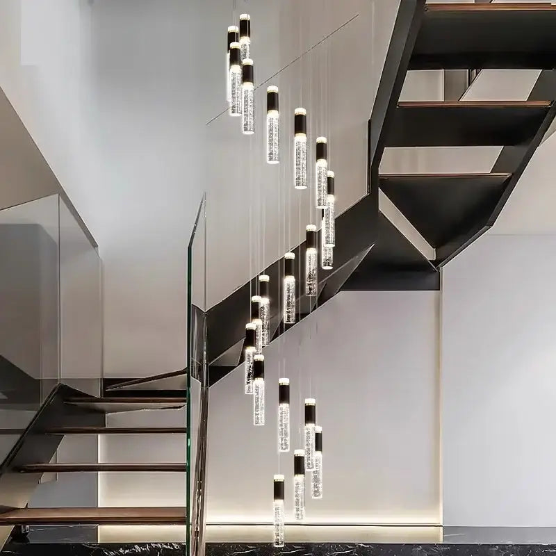 Decorbites crystal chandelier featuring clear glass cylinders with black caps as a chandelier stair pendant above staircase