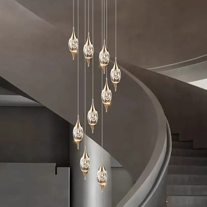Elegant gold-toned decorbites crystal chandelier with crystal-encrusted teardrop shades in modern staircase lighting