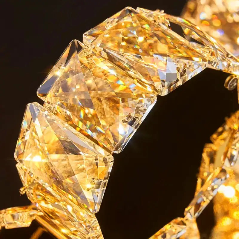 Gold-toned faceted crystal bracelet with geometric links complementing decorbites crystal chandelier stair lighting