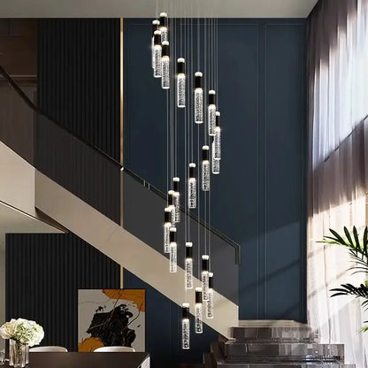Modern decorbites crystal chandelier with clear crystal-encrusted cylindrical pendants and black accents against dark blue wall