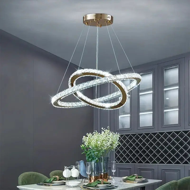 A modern gold-toned DecorBites crystal chandelier stair pendant light with two interlocking crystal rings