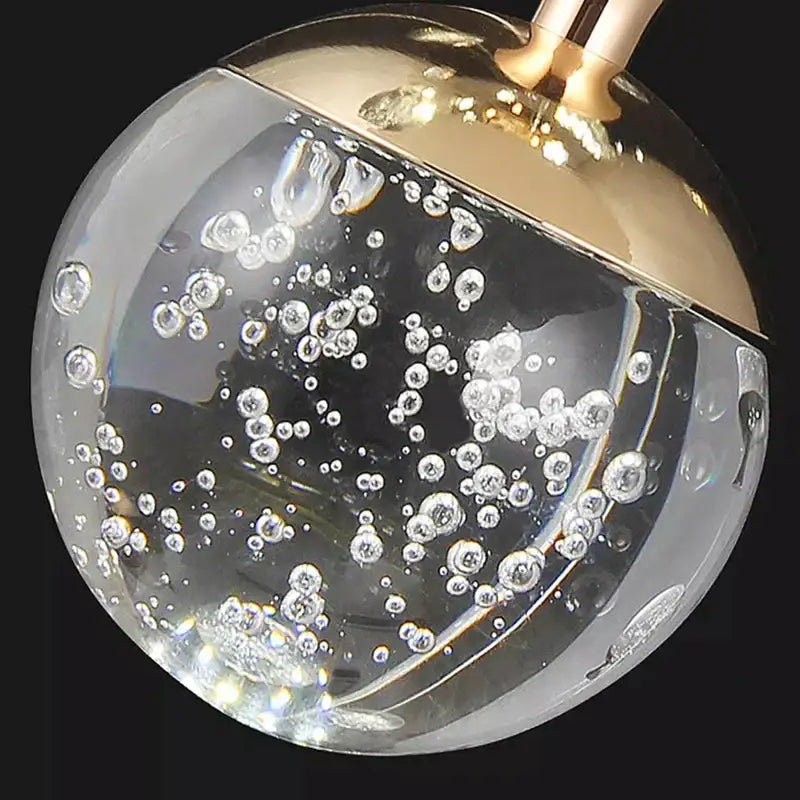 A clear glass sphere with gold-toned cap filled with bubbles for decorbites crystal chandelier stair pendant lamp