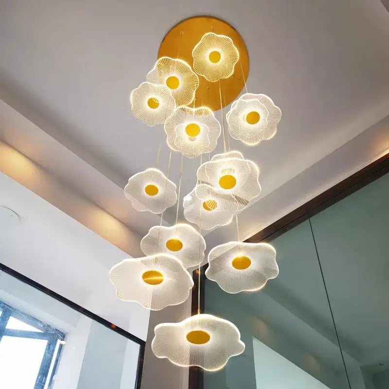 A decorbites crystal chandelier pendant light with illuminated flower-shaped lights and gold accents for stair lighting