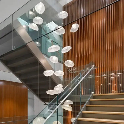 A modern decorbites crystal chandelier stair pendant featuring cascading translucent cloud-like glass orbs