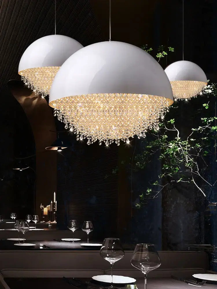 White dome pendant lights with decorbites crystal chandelier accents hanging from the living room ceiling