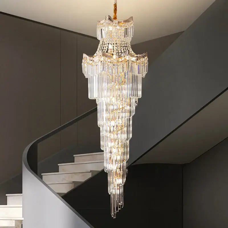 Decorbites crystal duplex chandelier with gold accents and cascading glass rods above a modern staircase