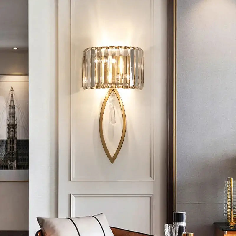 A modern decorbites crystal led black wall lamp with gold leaf frame and clear crystal prism shade for bedroom use