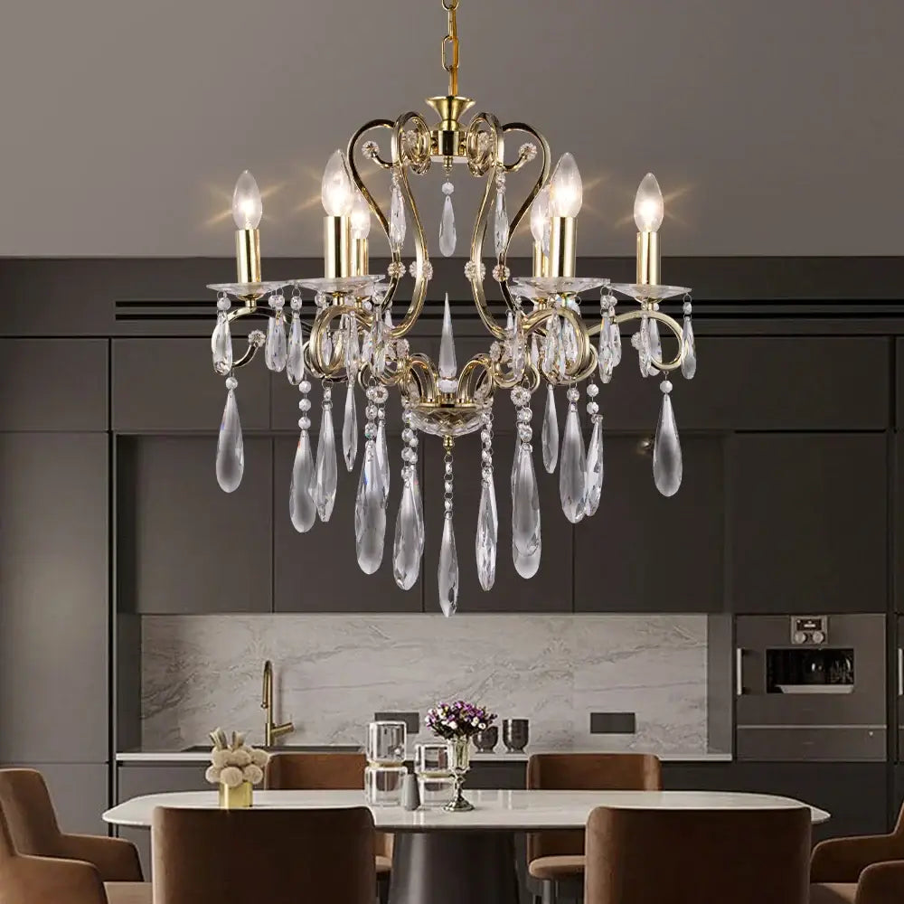 Elegant gold-toned decorbites crystal led chandelier with clear crystal droplets hanging above modern dining table