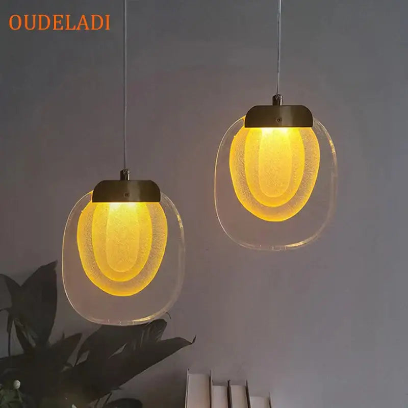 Two warm yellow decorbites crystal led pendant lights with frosted glass shades and metallic fixtures for kitchens