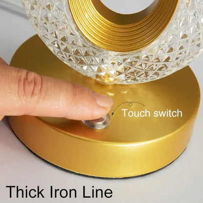 A modern decorbites crystal led table lamp with a gold base and clear faceted crystal glass shade for bedroom use