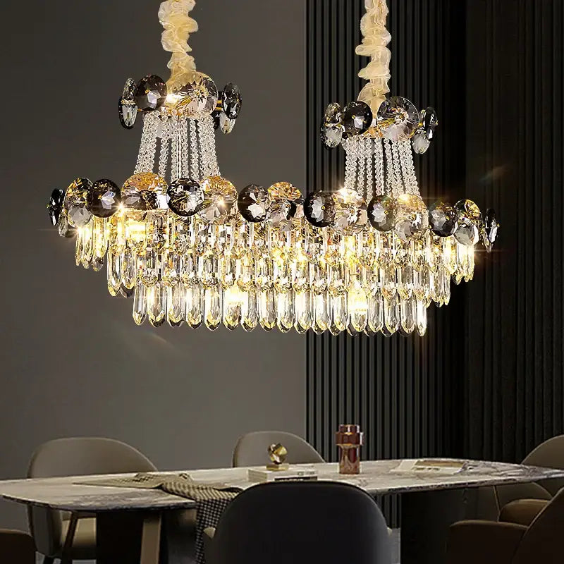 Luxury chandelier with a golden metallic frame and cascading smoke and crystal teardrops for dining room use