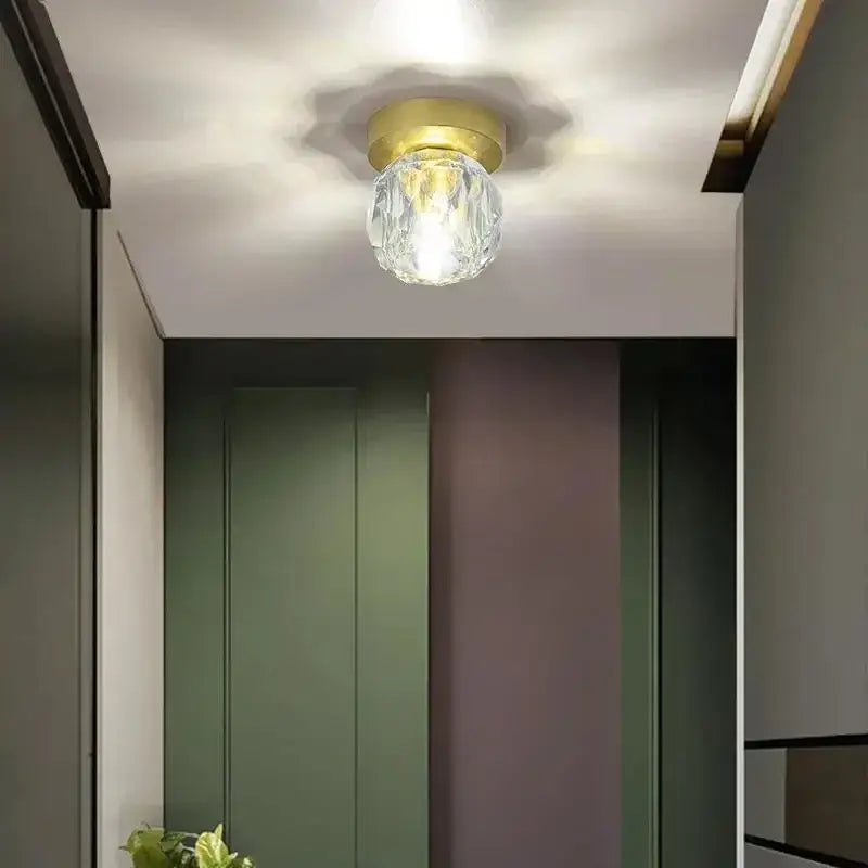 Modern gold crystal luxe ceiling lamp featuring a faceted glass globe and polished brass base for corridor lighting