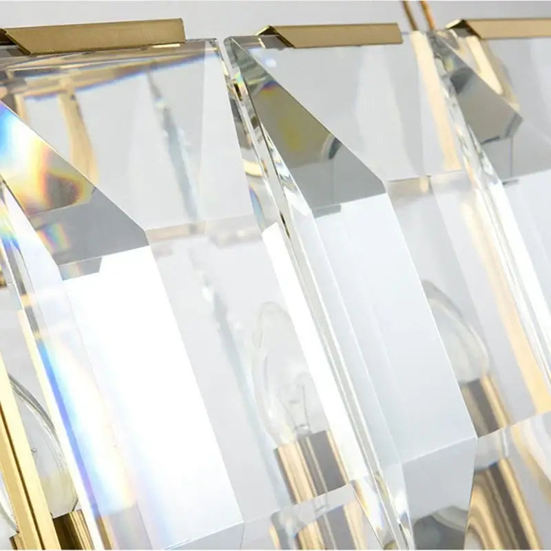 A modern decorbites crystal pendant chandelier with faceted crystal prisms and gold-toned metal accents for living room lighting