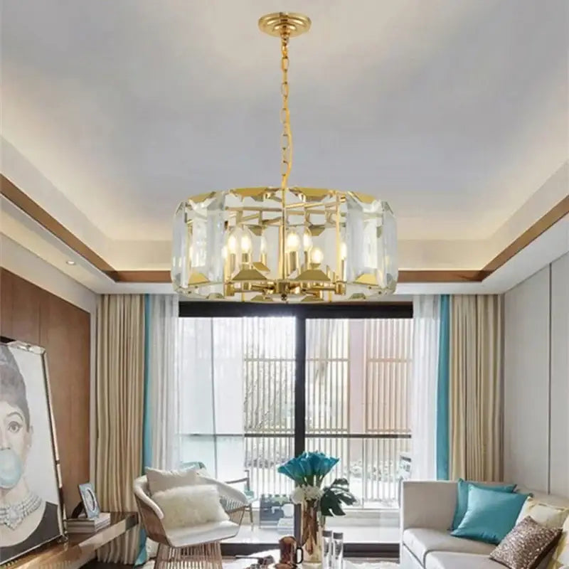 Gold-toned decorbites crystal pendant chandelier with clear faceted crystal panels and modern geometric design for living room light