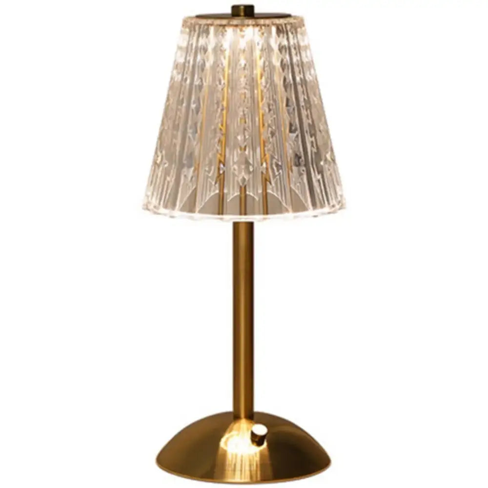 A sleek brass decorbites crystal retro table lamp with a faceted translucent crystal shade for bedside use
