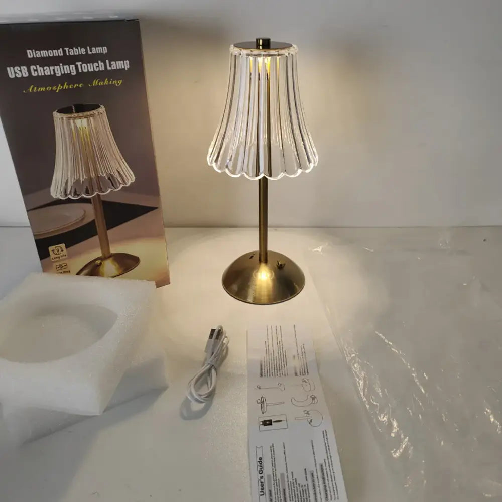 Brass-finished crystal retro table lamp with clear fluted glass shade emitting warm light for luxurious bedside use