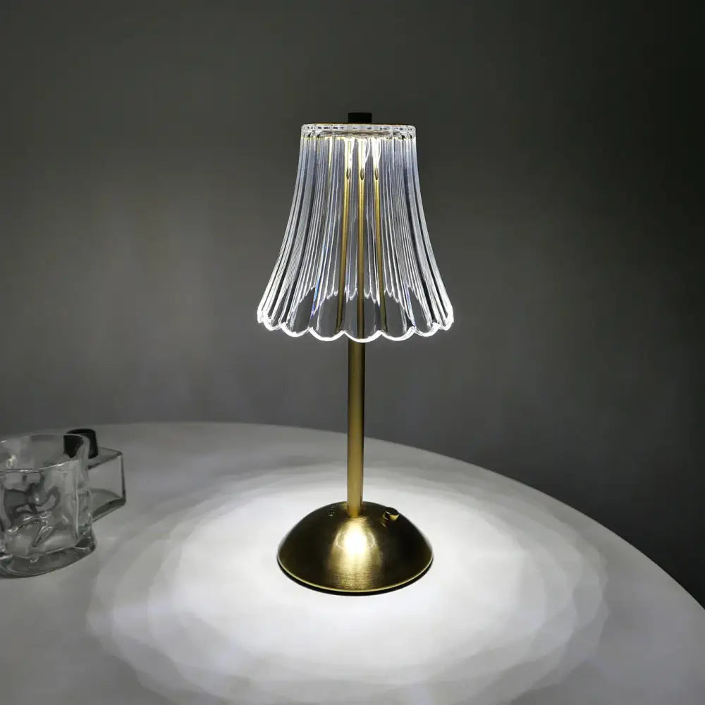 A decorbites crystal retro table lamp with a clear glass fluted shade and brass-finished base for bedside use