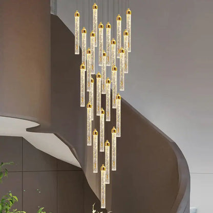 A modern decorbites crystal staircase chandelier with vertical translucent glass tubes and gold led caps for interiors