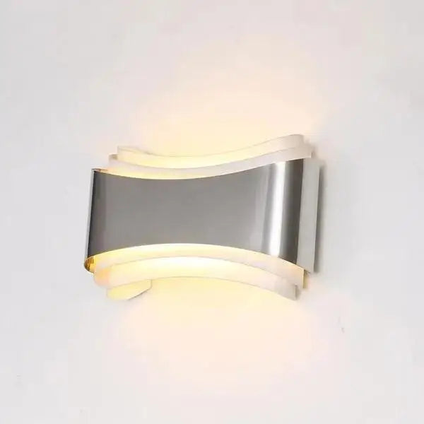 DecorBites™ curved modern wall sconce in silver tone with sleek design and warm LED lighting for modern wall decor