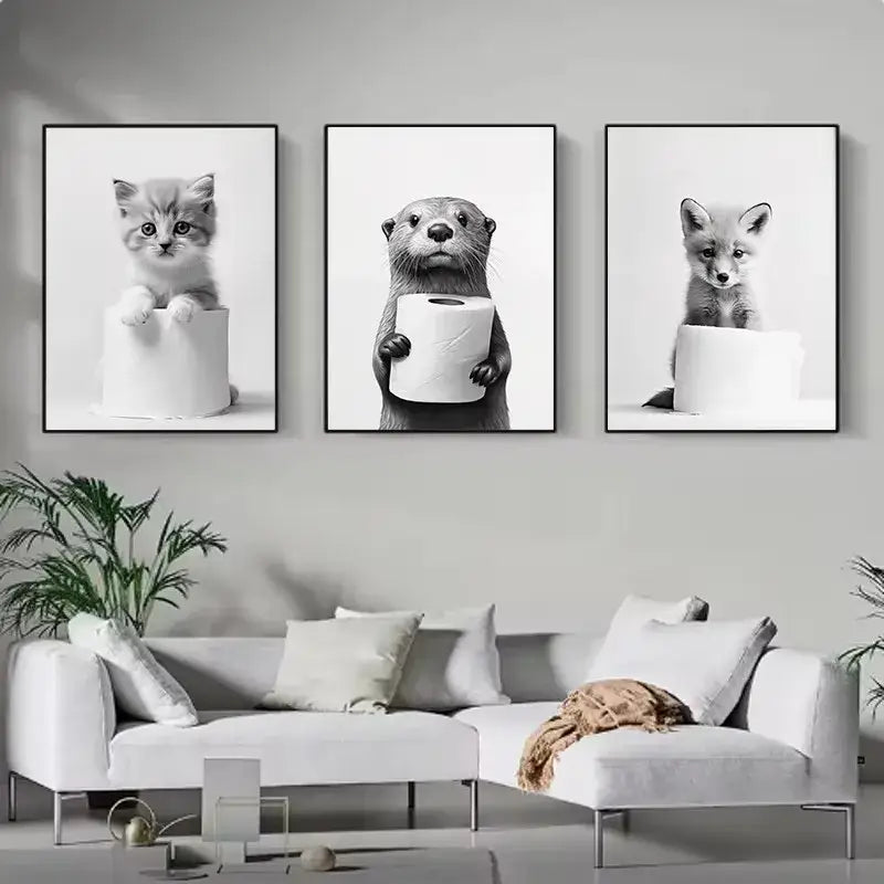 Set of three black-and-white framed cute animals canvas prints featuring a kitten, otter with toilet paper, and fox for bathroom decor