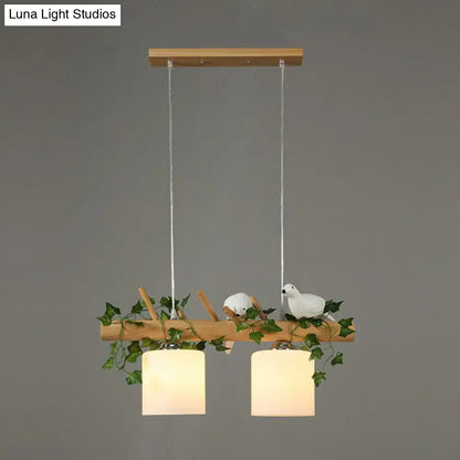Decorbites™ cylindrical milk glass pendant light with frosted shades and resin bird deco on a rustic wood branch