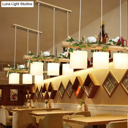 Wooden pendant light with white cylindrical milk glass shades and resin bird deco for country style restaurants