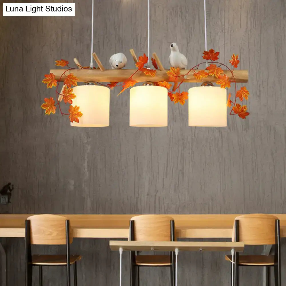 DecorBites™ rustic wooden pendant light with three white cylindrical shades and orange resin bird deco for country style