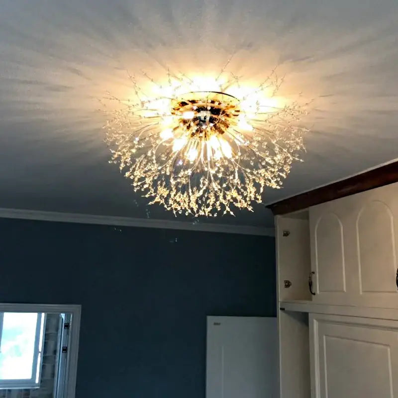 A sparkling gold and clear crystal decorbites dandelion chandelier with a radiant starburst design for living rooms