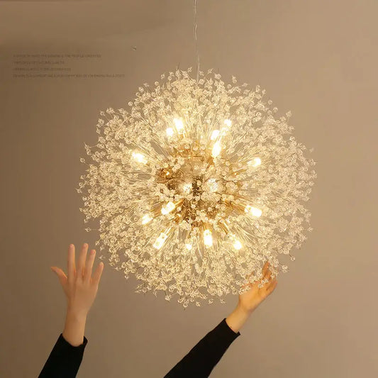 A decorbites dandelion chandelier featuring a gold-toned frame with clear crystal elements illuminated by warm lights