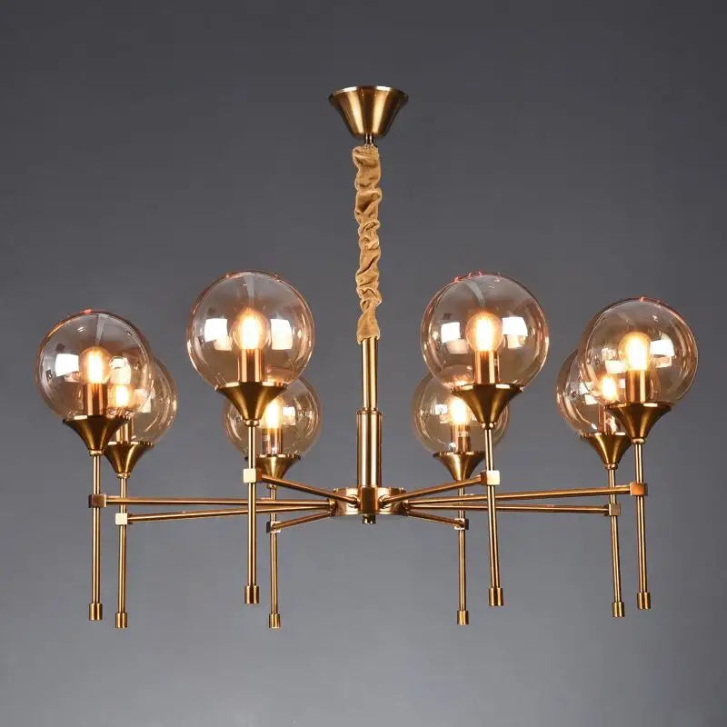 Brass-finished designer metal chandelier with six amber glass globes and twisted fabric-covered stem for modern living