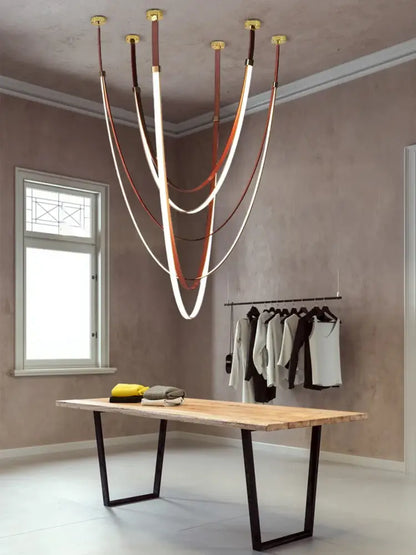 A modern DecorBites™ LED chandelier with multiple curved illuminated strips suspended by flexible leather belts in brown and white