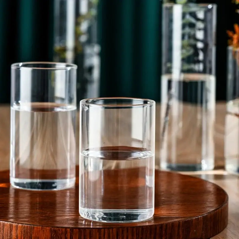 Clear glass cylinder vase tumbler with smooth cylindrical shape and slightly wider rim for elegant flower display