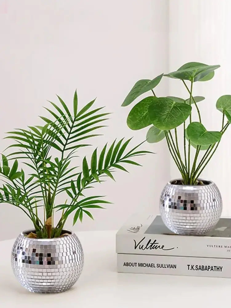 Two silver spherical DecorBites™ round glass vases with mirrored mosaic surfaces holding artificial green plants