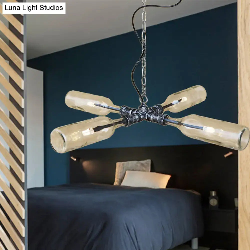 Industrial style chandelier with four smoke gray blue glass bottles on aged silver black metal hub and hanging chain
