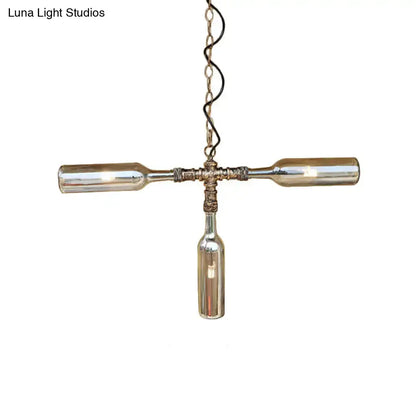 A rustic farmhouse style pendant light with three smoke gray blue glass bottles and aged silver black metal fixtures