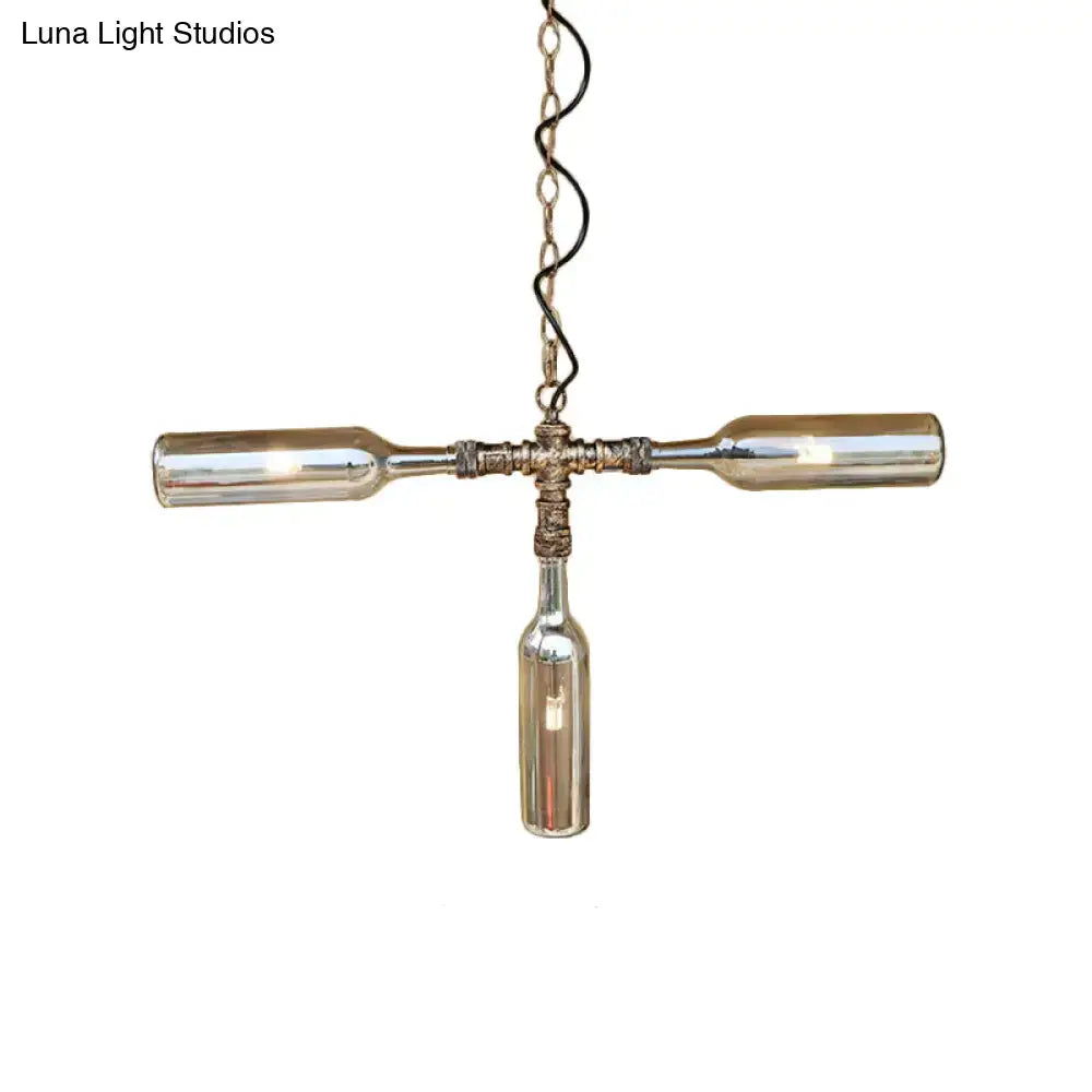 A rustic cross-shaped ceiling lighting pendant made from smoke gray blue glass wine bottles with aged silver black metal accents