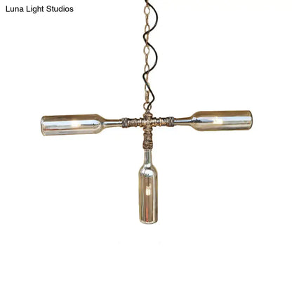 A rustic cross-shaped ceiling lighting pendant made from smoke gray blue glass wine bottles with aged silver black metal accents